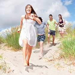 Group of people running on the beach.