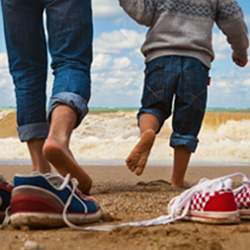 Parent and child walking on the beach